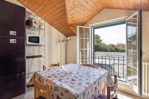 a dining room with a table and a balcony at La Casa di Lady in Ceriale