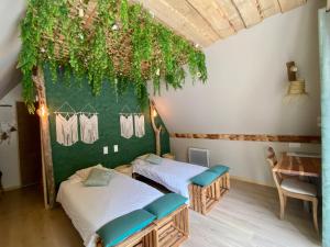 two beds in a room with plants on the wall at Célézen in Espagnac-Sainte-Eulalie