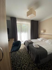 Pokój hotelowy z 2 łóżkami i biurkiem w obiekcie Ośrodek Warszawianka w Świnoujściu