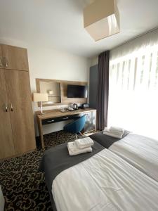 een hotelkamer met een groot bed en een bureau bij Ośrodek Warszawianka in Świnoujście