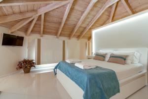 a bedroom with a large bed in a room with wooden ceilings at Chryssi Akti Family Villa and Studios in Argassi +17 photos