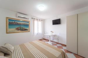 a bedroom with a bed and a desk in it at Pepigall Apartments in Alghero