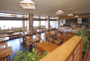 an empty restaurant with wooden tables and chairs at Hokkai Hotel in Lake Toya