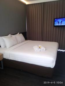 a hotel room with a bed with two towels on it at HOTEL PANTES SIMPANG LIMA SEMARANG in Semarang