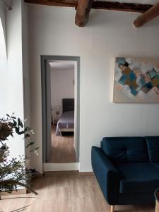ein Wohnzimmer mit einem blauen Sofa und ein Schlafzimmer in der Unterkunft AZUREO - Terrasse du golfe in Morsiglia