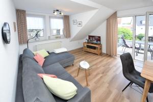 ein Wohnzimmer mit einem blauen Sofa und einem TV in der Unterkunft Albrecht-Jäger Fewo in Bad Sassendorf