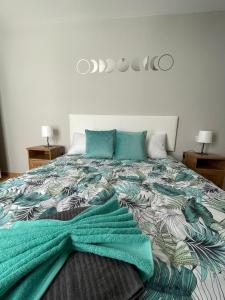 una camera da letto con un letto con una coperta verde sopra di ÁTICO "TURQUESA BEACH" CON PISCINA, TERRAZA y BARBACOA a Sardina