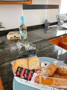 un piatto di pane e una bottiglia di alcol su un bancone di ÁTICO "TURQUESA BEACH" CON PISCINA, TERRAZA y BARBACOA a Sardina