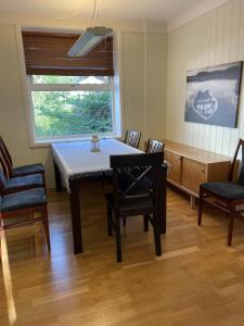 ein Esszimmer mit einem Tisch, Stühlen und einem Fenster in der Unterkunft Fjord Apartments in Dimmelsvik
