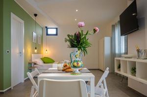 a living room with a table with a vase of flowers at Sunrise Luxury Apartments in Cassibile