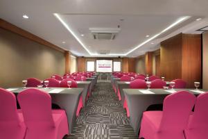 a conference room with pink chairs and tables at favehotel Sunset Seminyak in Seminyak