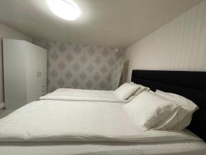 ein Schlafzimmer mit einem großen Bett mit weißer Bettwäsche in der Unterkunft Moonlight - Trevlig Källarlägenhet in Broby