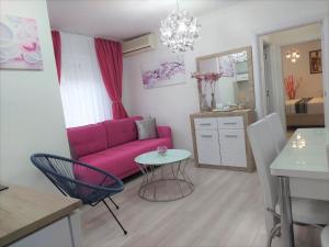 a living room with a pink couch and a table at City Lux Apartments in Skopje