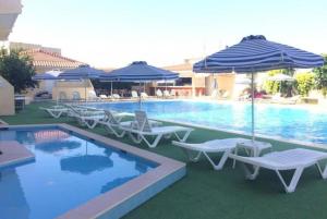 una piscina con sedie e ombrelloni e una piscina di Smart Accommodation Rhodes a Città di Rodi