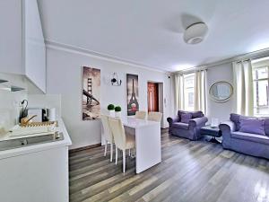 salon z białym stołem i fioletową kanapą w obiekcie Campari w Toruniu