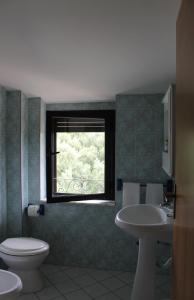 ein Bad mit einem WC, einem Waschbecken und einem Fenster in der Unterkunft Casa Nicotìria a 50mt dal mare in Nicotera Marina