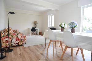 a white dining room with a table and chairs at Nia Azorean Apartments in Horta