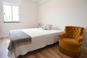 a bedroom with a bed and a chair at Nia Azorean Apartments in Horta