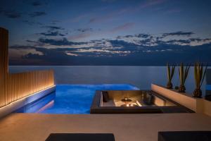 a swimming pool in the middle of the ocean at night at SEA ZANTE Luxury Beachfront Retreat in Tragaki