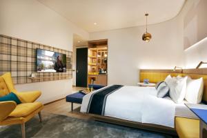 a hotel room with a bed and a chair at Citadines Connect City Centre Singapore in Singapore