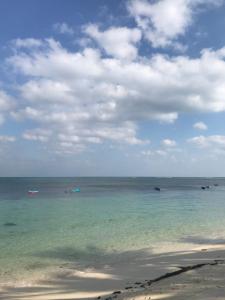 een uitzicht op de oceaan met boten in het water bij Talenta Mas Homestay in Nembrala