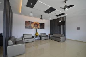 una sala d'attesa con divani e ventilatore a soffitto di AST Hotel a Alor Setar