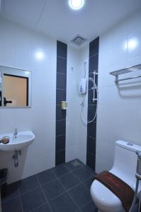 a bathroom with a toilet and a sink at AST Hotel in Alor Setar