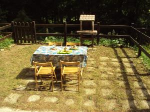 ein Tisch mit Stühlen und ein Teller mit Essen drauf in der Unterkunft Casa nel bosco in Livata