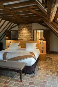 a bedroom with a large bed and a brick wall at Hostellerie De Levernois in Levernois