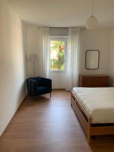ein Schlafzimmer mit einem Bett, einem Stuhl und einem Fenster in der Unterkunft casa Dante in Riva del Garda