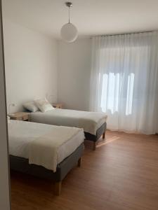 1 Schlafzimmer mit 2 Betten und einem Fenster in der Unterkunft casa Dante in Riva del Garda