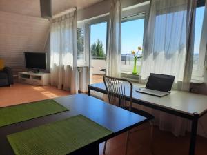 ein Wohnzimmer mit einem Schreibtisch und einem Laptop darauf in der Unterkunft Komfort Apartment 1 DG Jürgen Kunzi in Filderstadt