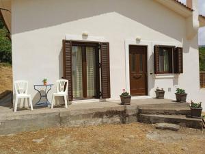 Biały dom z dwoma krzesłami i stołem w obiekcie Galini Home: Cozy Home with great view of Taygetos 