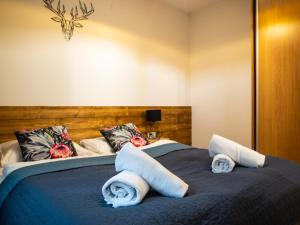 シュチルクにあるApartament Lux View Szczyrk Sauna Jacuziiのベッドルーム1室(大型ベッド1台、タオル付)