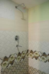 a bathroom with a shower with flowers on the wall at Kathway Hostel & Homestay in Kathmandu