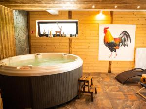 a hot tub in a room with a rooster on the wall at Apartament Lux View Szczyrk Sauna Jacuzii in Szczyrk