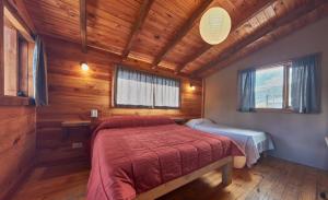 1 dormitorio con 1 cama en una cabaña de madera en Cabañas Hechas a Mano con Vista al Cerro Catedral en San Carlos de Bariloche