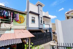 une maison avec un tableau sur son côté dans l'établissement SPOT ON 91190 Pondok Bijaksana, à Bandung