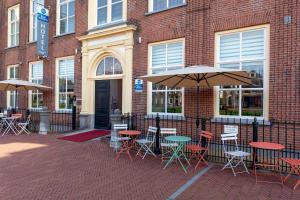 un gruppo di tavoli e sedie con ombrelloni di fronte a un edificio di Grand Museum Hotel, BW Signature Collection a Delft