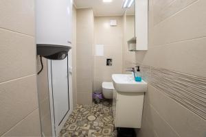 a small bathroom with a sink and a toilet at Апартамент за гости Русе Център-Придунавска (Дунав) in Ruse +11 photos