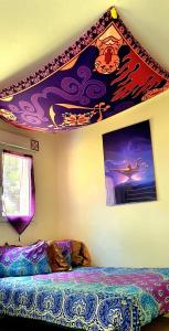 1 dormitorio con 1 cama y una pintura en la pared en Aladdin and Jasmine's near Disney, en Chalifert