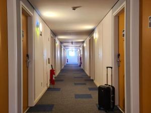 a hallway with a door leading to a room with a blue floor at ibis budget Petropolis in Petrópolis