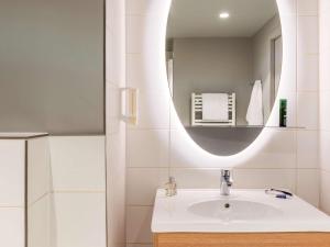 a bathroom with a sink and a mirror at Adagio Access Stuttgart Airport Messe in Leinfelden-Echterdingen