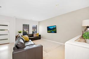 a living room with a couch and a table at Central Warrnambool Townhouse in Warrnambool