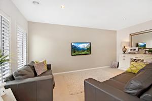 a living room with a couch and a mirror at Central Warrnambool Townhouse in Warrnambool
