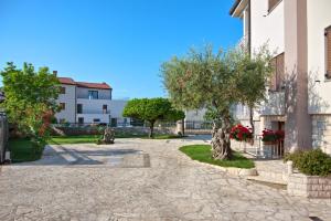 a courtyard of a building with trees and buildings at Apartments Vili in Umag