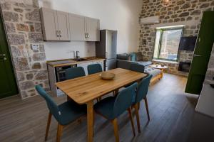 里曼尼的住宿－ERMIS-APEA Villas，厨房以及带木桌和椅子的用餐室。