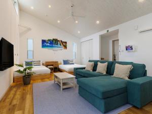 sala de estar con sofá azul y cama en la ohana～瀬底島～（2022年OPEN） en Okinawa City