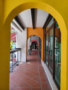 an arcade of a building with yellow walls and red tiles at The Boutique Residence Hotel in George Town