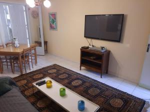 ein Wohnzimmer mit einem Flachbild-TV und einem Tisch in der Unterkunft Le Cerizay Gîte n°1 in Cerizay